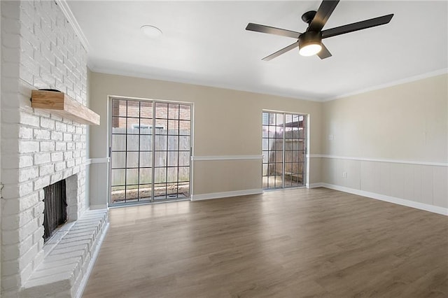 unfurnished living room featuring crown molding, hardwood / wood-style floors, ceiling fan, and a brick fireplace