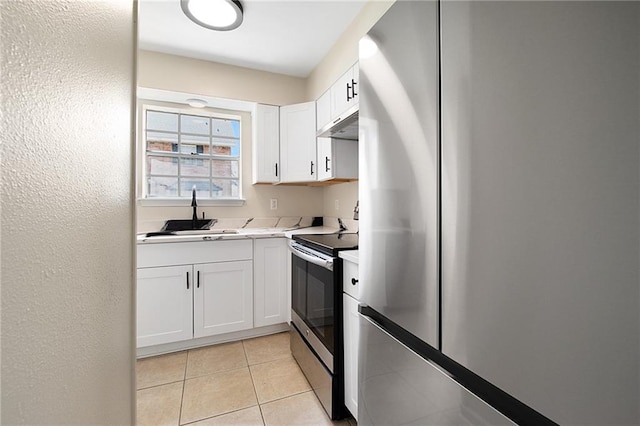 kitchen with sink, white cabinetry, light tile patterned floors, and stainless steel appliances