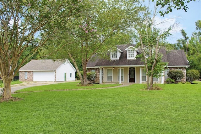 cape cod house with an outbuilding, a garage, driveway, and a front lawn