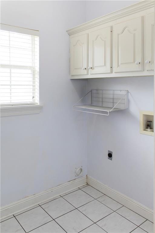 laundry room with cabinets, hookup for a washing machine, hookup for an electric dryer, and light tile patterned floors