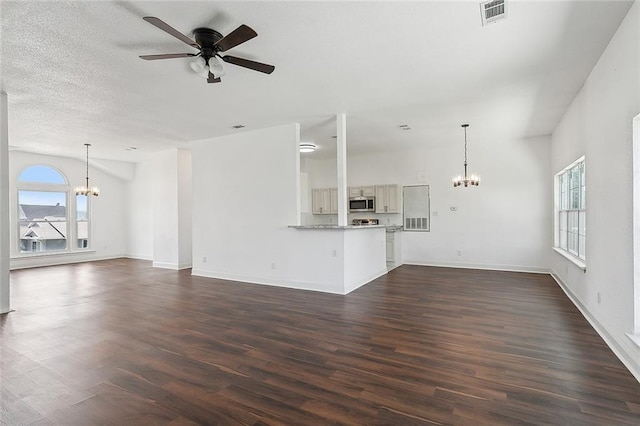 unfurnished living room featuring a textured ceiling, ceiling fan with notable chandelier, and dark hardwood / wood-style floors