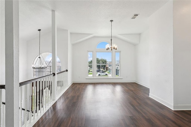 interior space with dark wood-type flooring, vaulted ceiling, and a notable chandelier