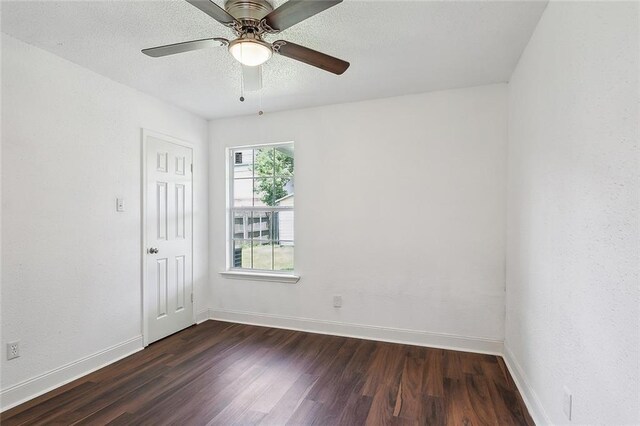 empty room with ceiling fan and dark wood-type flooring