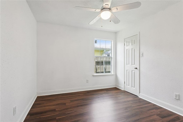 empty room featuring ceiling fan and dark hardwood / wood-style flooring