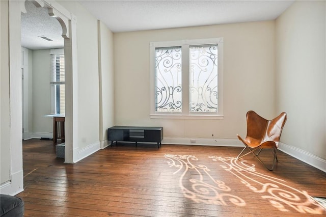 living area featuring a textured ceiling and hardwood / wood-style floors