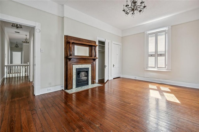 unfurnished living room with wood-type flooring and a chandelier