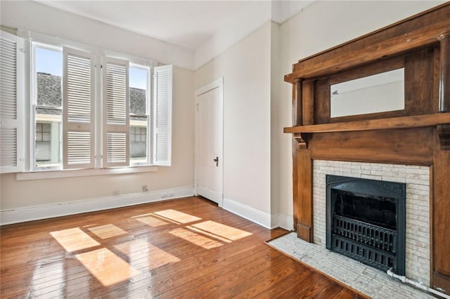 593739 Freret St, New Orleans, LA 70115 - unfurnished living room featuring wood-type flooring and a brick fireplace