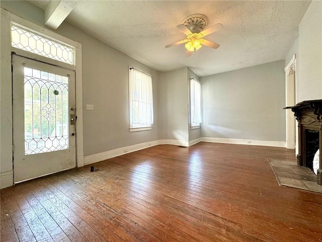 entryway with beam ceiling, a textured ceiling, hardwood / wood-style floors, and ceiling fan