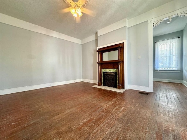 unfurnished living room with a textured ceiling, a fireplace, wood-type flooring, and ceiling fan