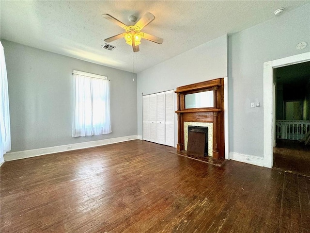 593739 Freret St, New Orleans, LA 70115 - unfurnished living room with a ceiling fan, a fireplace, wood finished floors, and a textured ceiling