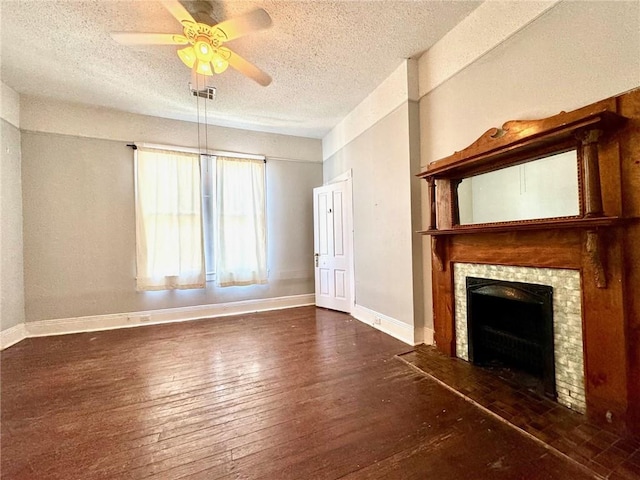 unfurnished living room with dark wood-type flooring, a textured ceiling, and ceiling fan