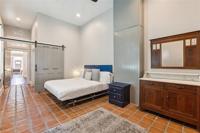 tiled bedroom with a towering ceiling, a closet, and a barn door