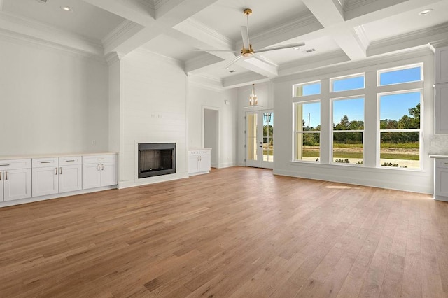 unfurnished living room featuring coffered ceiling, beam ceiling, light hardwood / wood-style flooring, ornamental molding, and a fireplace