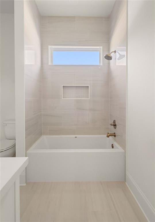 full bathroom featuring vanity, tiled shower / bath combo, and toilet