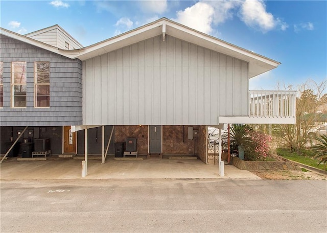 exterior space featuring a balcony, central AC, and a carport