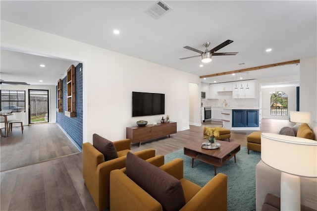 living room featuring ceiling fan and hardwood / wood-style flooring