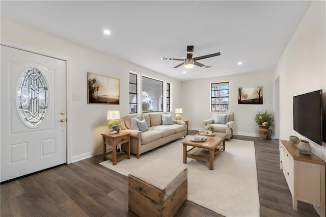 living room featuring dark wood-type flooring and ceiling fan