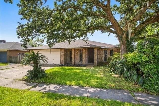 single story home with a garage and a front yard