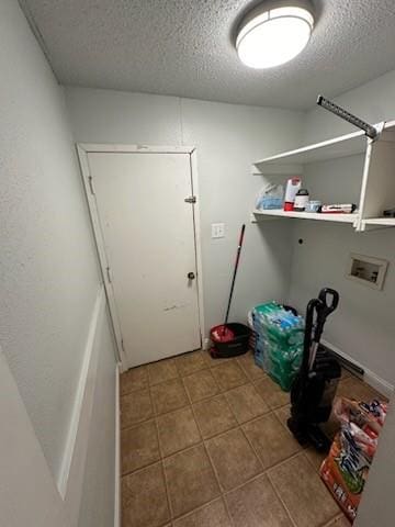 laundry area featuring a textured ceiling, tile patterned flooring, and washer hookup