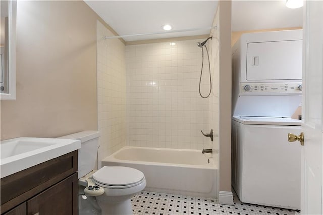 full bathroom featuring stacked washer / dryer, tile patterned flooring, vanity,  shower combination, and toilet