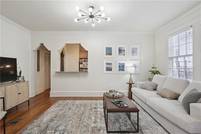 living room featuring a notable chandelier, crown molding, and hardwood / wood-style floors