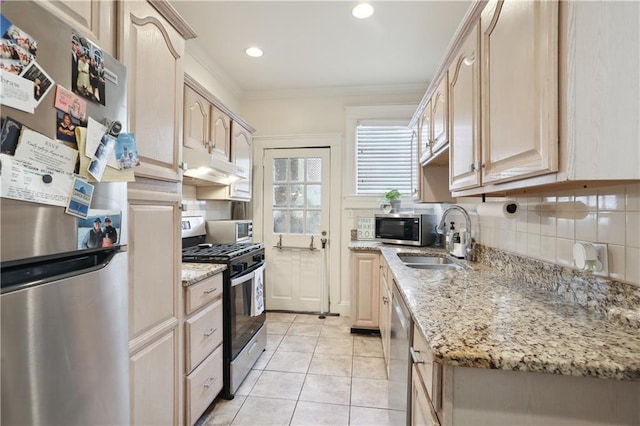 kitchen featuring light tile patterned floors, appliances with stainless steel finishes, light brown cabinetry, decorative backsplash, and ornamental molding