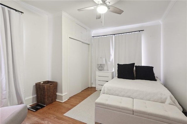 bedroom with crown molding, light wood-type flooring, and ceiling fan