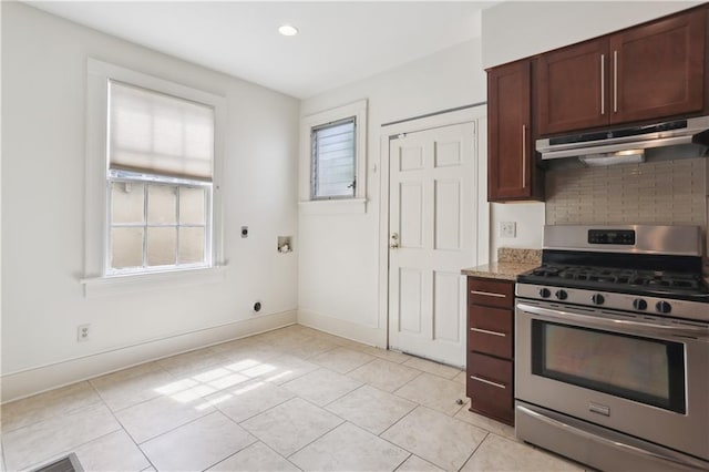 kitchen featuring light tile patterned flooring, decorative backsplash, light stone countertops, and stainless steel gas range oven