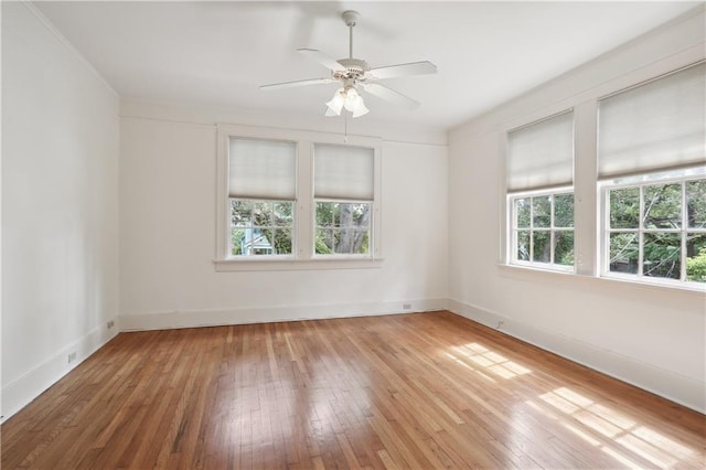 spare room with ceiling fan, ornamental molding, hardwood / wood-style flooring, and a healthy amount of sunlight