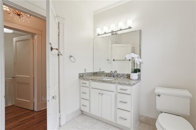 bathroom featuring vanity, hardwood / wood-style flooring, toilet, and crown molding