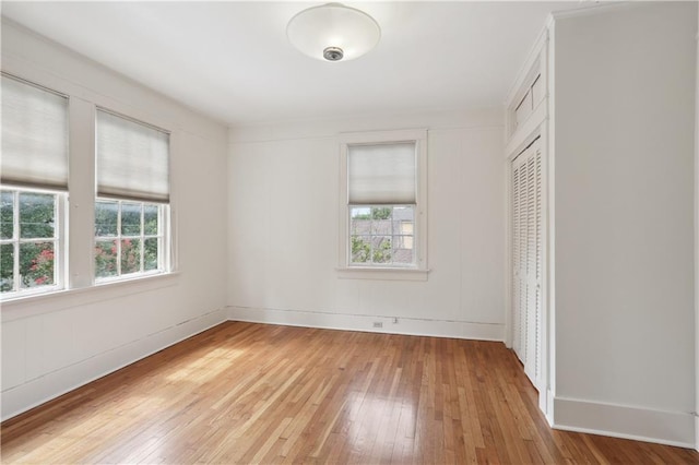 unfurnished bedroom with light hardwood / wood-style flooring and a closet