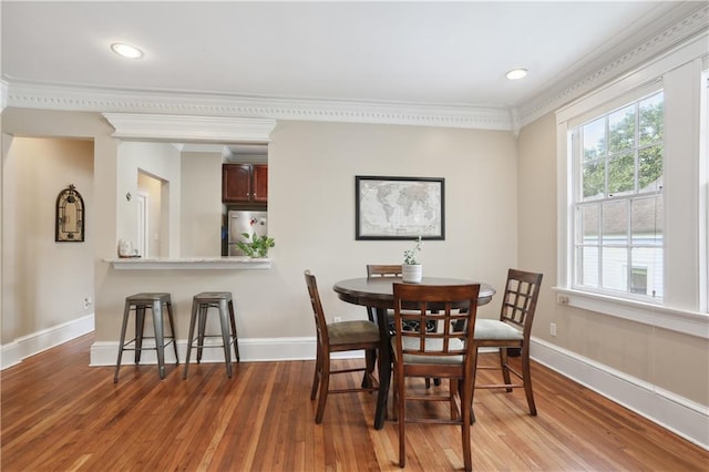 dining room featuring wood-type flooring and ornamental molding