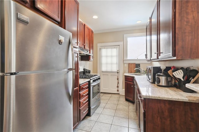 kitchen with light tile patterned flooring, stainless steel appliances, light stone countertops, and sink