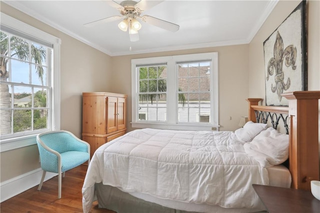 bedroom featuring ornamental molding, multiple windows, ceiling fan, and hardwood / wood-style floors