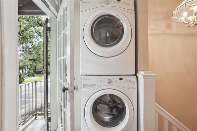 2900-04 Esplanade Ave, New Orleans, LA 70119 - laundry room featuring stacked washing machine and dryer, a chandelier, and a wainscoted wall