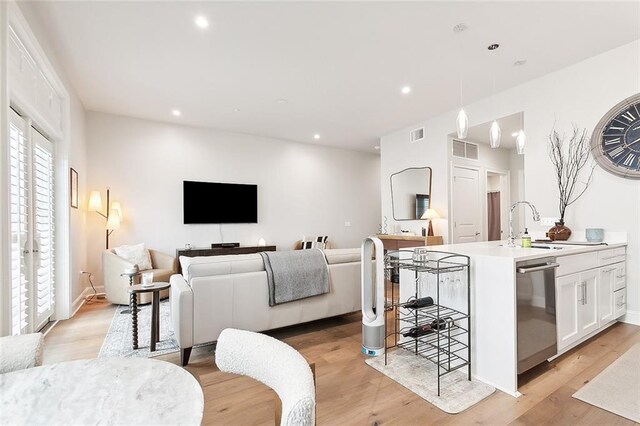 living room with sink and light wood-type flooring