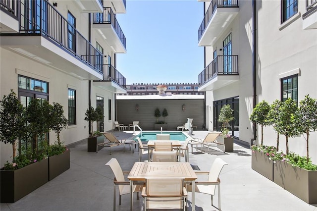 view of patio with a balcony and a fenced in pool