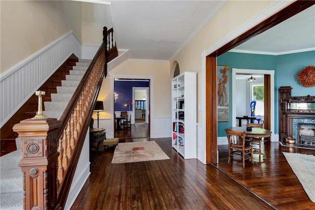 interior space featuring ceiling fan, dark wood-type flooring, and ornamental molding