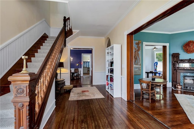 foyer featuring a high end fireplace, stairway, hardwood / wood-style flooring, and ornamental molding