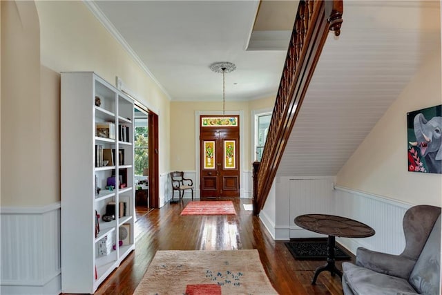 entryway featuring dark wood finished floors, crown molding, and wainscoting