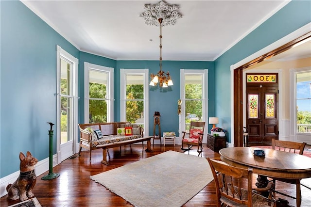 dining area featuring a chandelier, dark wood finished floors, and crown molding