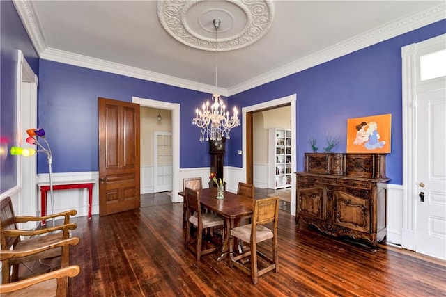 dining space with an inviting chandelier, crown molding, and hardwood / wood-style floors