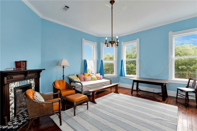 living area featuring hardwood / wood-style floors, ornamental molding, an inviting chandelier, and a premium fireplace