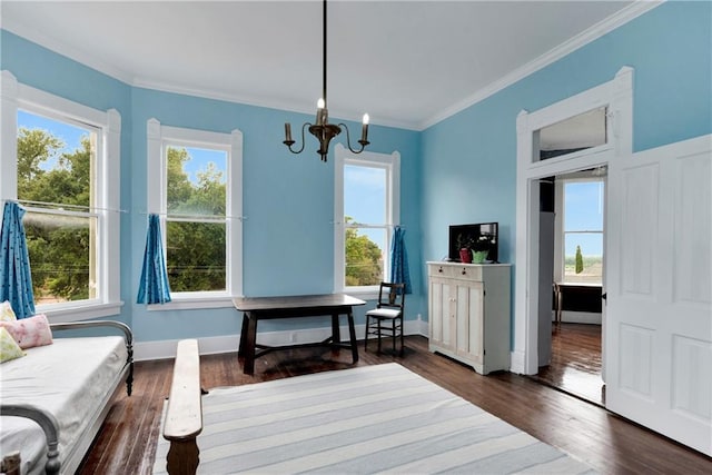 sitting room featuring dark wood-type flooring, ornamental molding, and an inviting chandelier