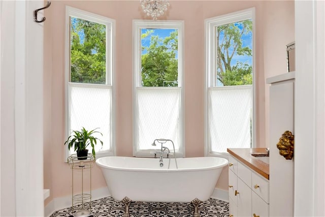 bathroom with a tub, tile patterned floors, and vanity