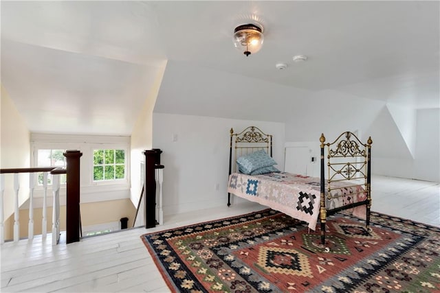 bedroom with light hardwood / wood-style floors and vaulted ceiling