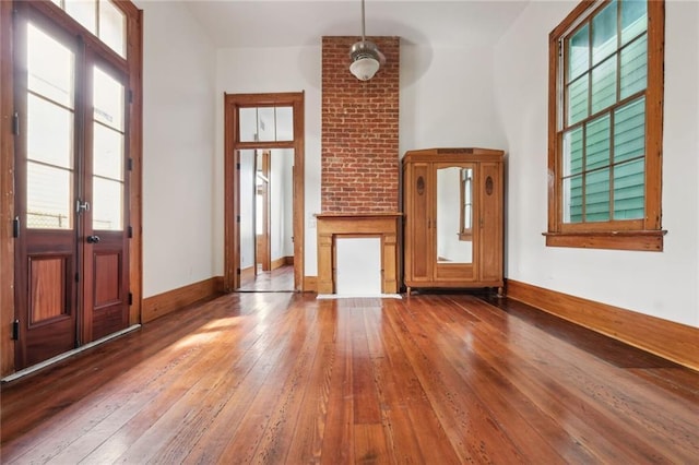 1915 Governor Nicholls St, New Orleans, LA 70116 - unfurnished living room featuring hardwood / wood-style flooring, healthy amount of natural light, and baseboards
