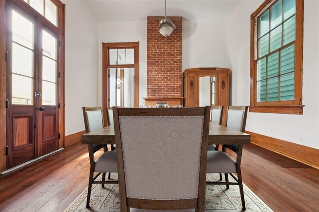 dining area featuring hardwood / wood-style floors, baseboards, and french doors
