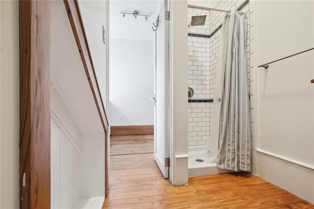 bathroom with a shower stall and wood finished floors