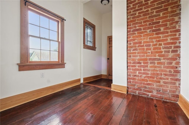 spare room featuring wood finished floors and baseboards